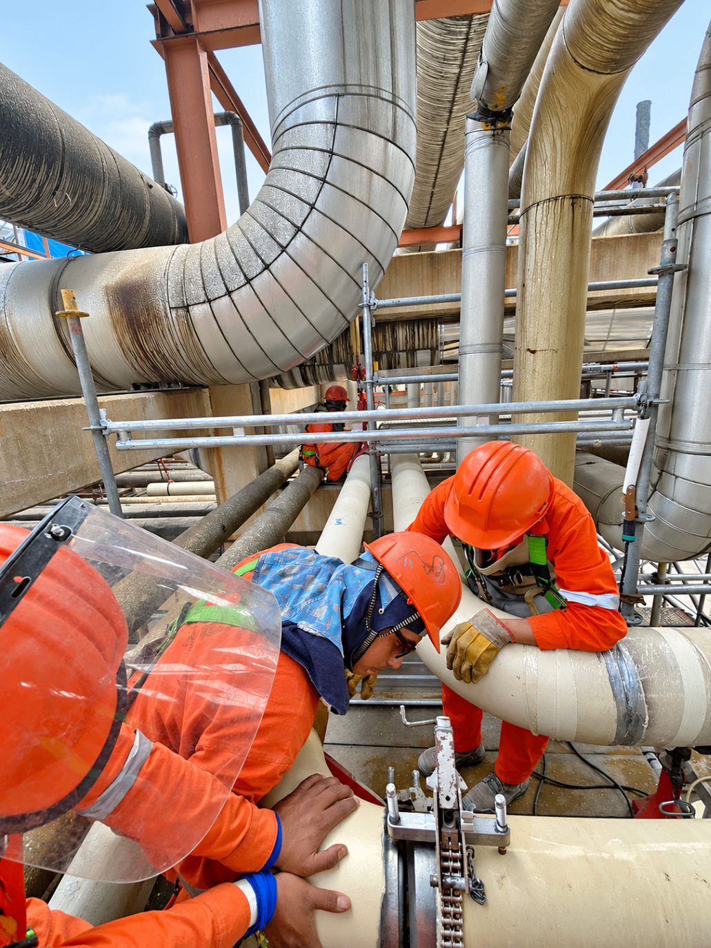 Cuadrilla realizando corte y armado de tubería aislada en altura
